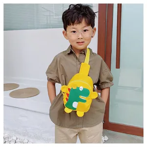 Photo en extérieur d'un enfant portant le sac bandoulière dinosaure jaune avec patch vert
