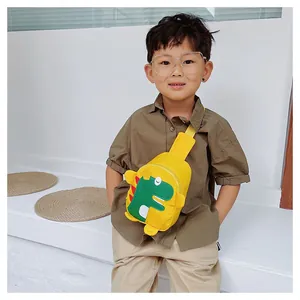 Sac bandoulière dinosaure jaune pour enfant avec sangle ajustable porté par un garçon