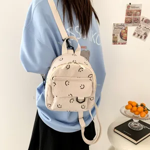 Minimalist corduroy smiley face backpack in beige with front pocket and zipper detail