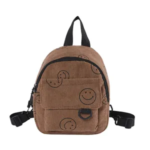 Brown corduroy mini backpack with black smiley patterns and adjustable shoulder straps