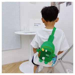 Détail d'un sac de poitrine dinosaure vert avec épines rouges et motifs d'étoiles jaunes