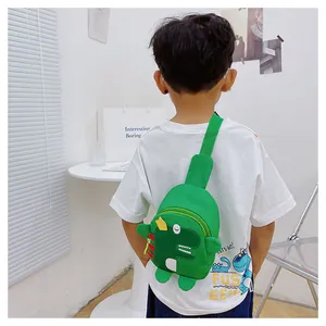 Sac de poitrine dinosaure vert pour enfant porté au dos dans un décor épuré et lumineux