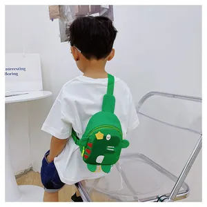 Vue de dos d'un enfant portant un sac de poitrine dinosaure vert avec bandoulière réglable