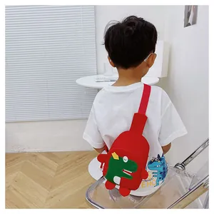 Enfant portant un sac bandoulière dinosaure rouge dans un intérieur moderne et lumineux