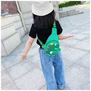 Gros plan d'un sac de poitrine dinosaure vert pour enfants avec piques rouges et couronne