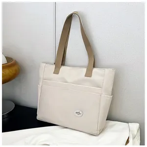 Close-up of canvas tote bag featuring stitched pockets and Good Luck patch detail