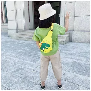 Détail du sac de poitrine dinosaure jaune sur enfant avec motif de dessin animé vert