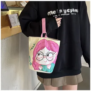 Close-up of a cute canvas bucket bag with a cartoon girl print and pink handles