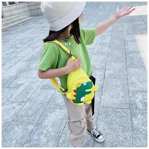 Photo en extérieur d'un enfant portant un sac de poitrine dinosaure jaune vif