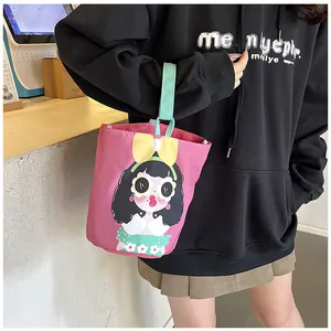 Pink cartoon canvas bucket bag with mint green handles shown in a lifestyle setting