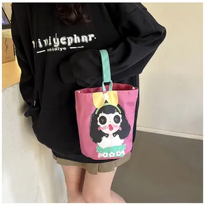 Detail of cute pink bucket bag with cartoon girl illustration and mint green handle