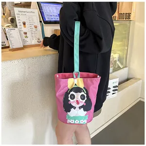 Close-up of pink canvas bucket bag with cute girl illustration in a cafe setting