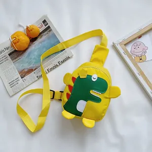 Détail d'un sac à bandoulière jaune pour enfant avec broderie dinosaure de dessin animé