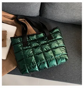 Detailed close-up of quilted emerald green puffer tote bag with glossy metallic finish