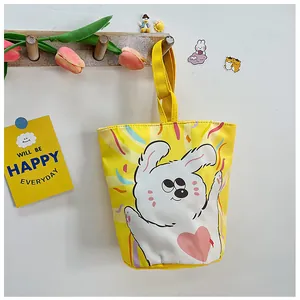 Detail of yellow canvas bucket bag featuring cute cartoon illustration and sturdy handle