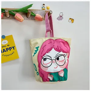 Detailed view of canvas bucket bag with cute cartoon girl illustration on a wooden hook