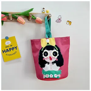 Detail of cute canvas bucket bag with cartoon girl print and green handle accents