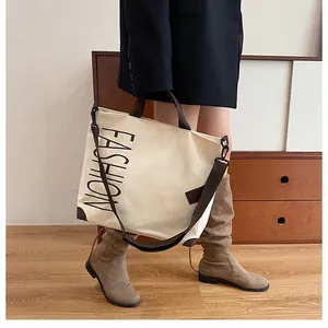 Lifestyle shot of large canvas tote bag with brown trim and adjustable crossbody strap