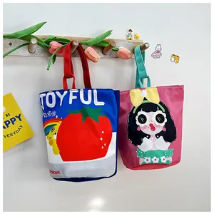 Detailed view of two cute illustrated canvas bucket bags hanging on a wooden rack