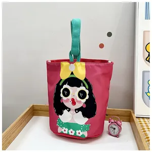 Detail of pink canvas bucket bag featuring cute girl illustration and green handle