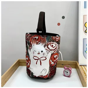 Close-up of canvas bucket bag with cute bunny and rose print on a wooden tray