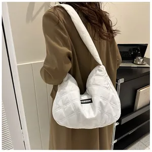 Sac fourre-tout matelassé blanc avec étiquette FASHION porté par un mannequin chic