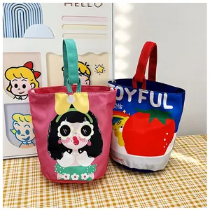 Detail of cute canvas bucket bags with colorful handles and cartoon girl illustration