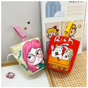Detail of cute canvas bucket bags with cartoon girl and lucky cat illustrations