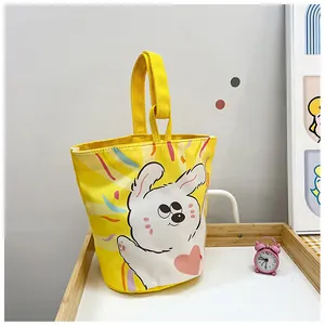Detailed view of yellow canvas bucket bag with cute white rabbit and pink heart illustration