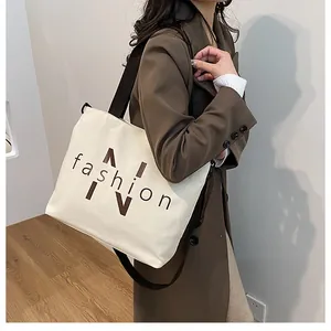 Detail view of the cream canvas tote bag showing the fashion print and adjustable strap