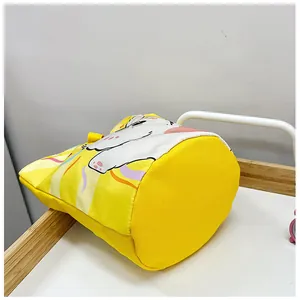 Close-up of yellow canvas bucket bag showing round base and cute unicorn illustration