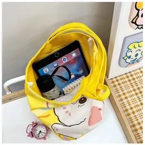 Top view of yellow canvas bucket bag showing capacity for tablet and notebook