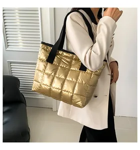 Detailansicht der gold gesteppten Textur und des schwarzen Riemens der Wintertasche