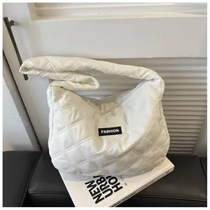 Detail van een witte gewatteerde crossbodytas met een zwart FASHION-label erop