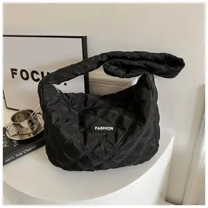 Détail d'un sac cabas noir matelassé avec surpiqûres en losange et étiquette tendance