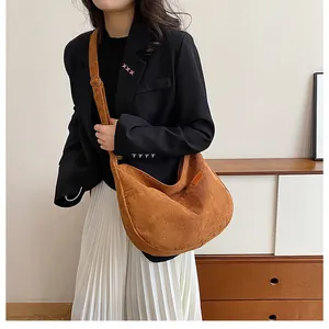 Detail of brown corduroy hobo bag showing ribbed texture and adjustable strap