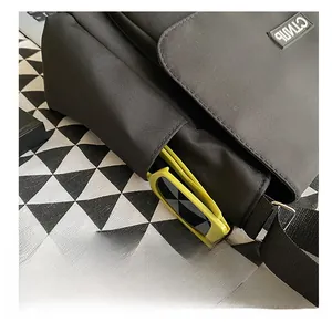 Detail view of the black nylon messenger bag side pocket with stylish sunglasses