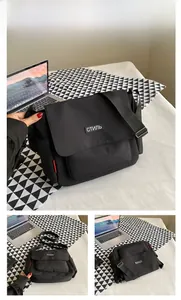 Detail of black crossbody messenger bag with white label and adjustable strap