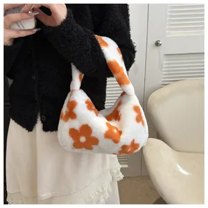 Dettaglio della borsa in peluche con fiori arancioni su pelliccia sintetica bianca