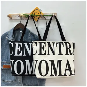 Detail of minimalist black and white canvas tote bags with bold letter printing