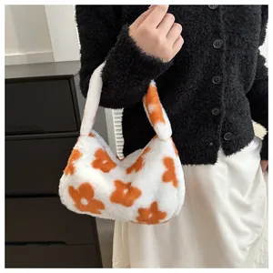 Borsa a mano in peluche bianca con fiori arancioni indossata da modella in posa