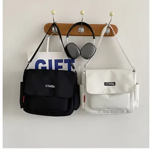 Detail of minimalist canvas messenger bags with Cyrillic text labels on white background