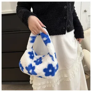 Dettaglio della borsa a mano in peluche a fiori bianchi e blu con consistenza morbida