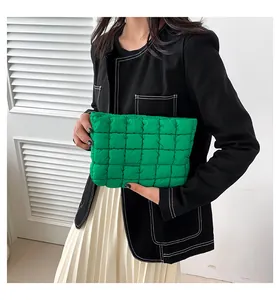 Nahaufnahme der hellgrünen gesteppten Puff-Clutch, von einem Model minimalistisch gehalten