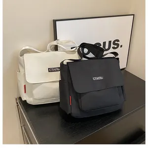 Detail of minimalist black and white messenger bags with stylish Russian text patches