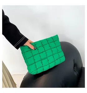 Gesteppte grüne Puffy-Kosmetiktasche mit weicher Textur für Reisen in der Hand