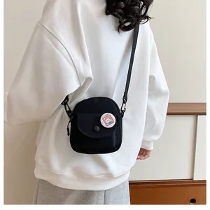 Détail d'un petit sac en toile noire avec un badge lapin mignon et une fermeture à pression