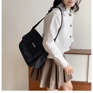 Detail showing high-quality black canvas texture and white Cyrillic text on the messenger bag