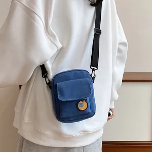 Blue canvas crossbody bag for women with orange fruit patch and adjustable strap
