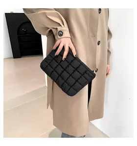 Detail einer schwarzen gesteppten Puff-Handtasche mit weicher Wattierung und Karomuster